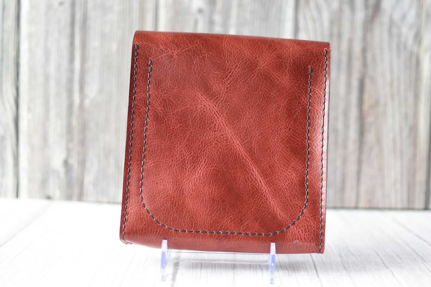 Red leather purse with a antique brass clasp on a white background