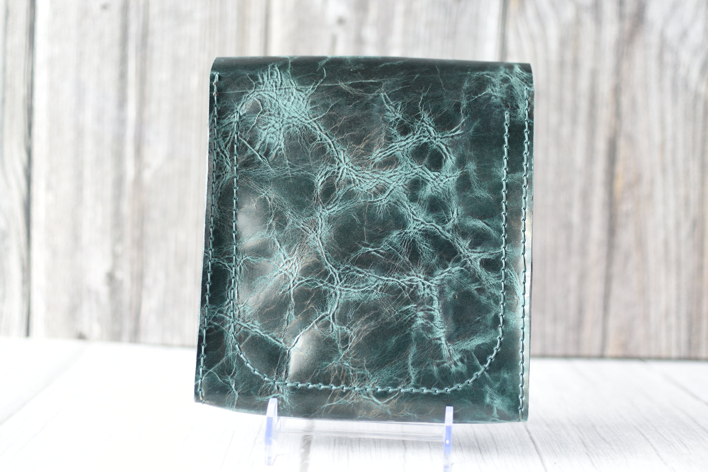 Green marbled purse with a gold clasp on a white background